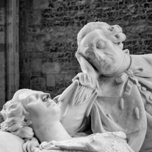 Black and white photograph of stone cherub and saint sculptures with detailed carving, showing religious artwork from Dorset churches interior by Jim Johnson