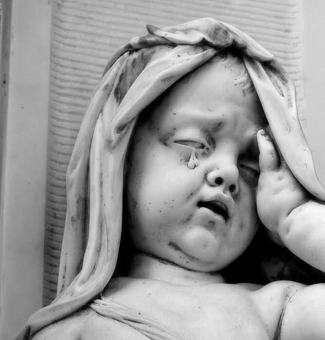 Black and white photograph of a stone sculpture showing a veiled face in profile, carved religious monument detail from Jim Johnson's Dorset churches photography project"
