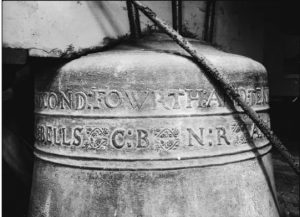 The tenor bell cast in 1681 by Thomas Purdue at Lydlinch Church, photographed in black and white. Latin and decorative engravings are visible on the bell's surface, along with ropes for ringing. This is one of the five bells immortalised in William Barnes' 1879 poem Lydlinch Bells
