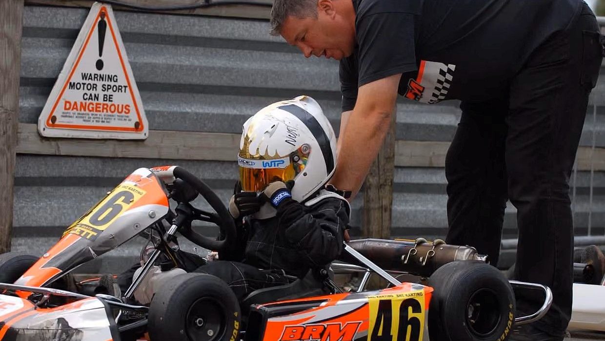 A young Lando Norris in his go-kart at Clay Pigeon Raceway, being coached by Rob Dodds of BKC Racing