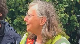 Carol King, one of the organisers of the campaign against Dorset and Wiltshire Fire and Rescue station closures, smiling in a high-vis vest at the bucket chain event