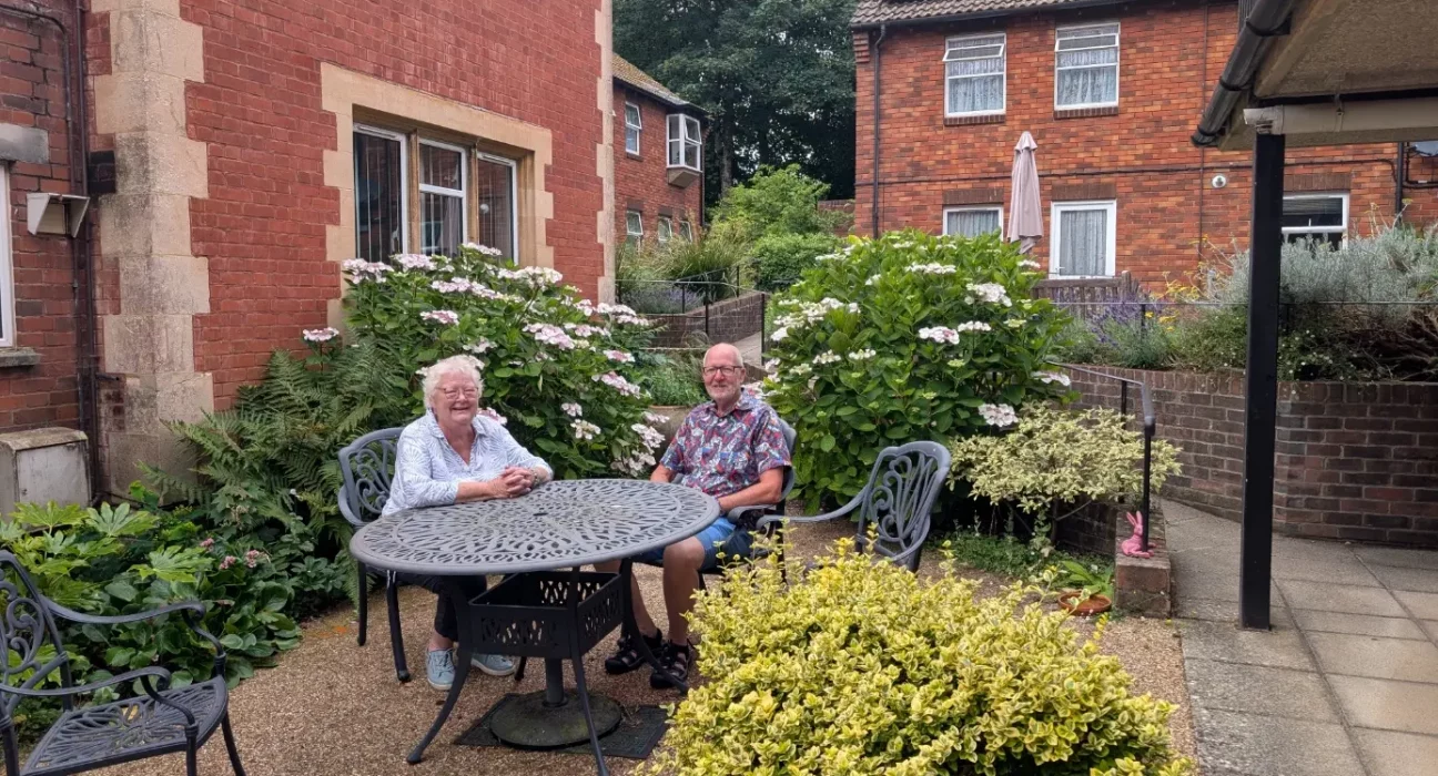 Molly Rennie and John Christmas of Dorchester Almshouses sit together in the garden of the Whetstones social housing scheme in West Walks, Dorchester