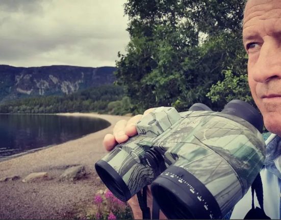 Steve Feltham scans Loch Ness with binoculars during his search for the Loch Ness Monster