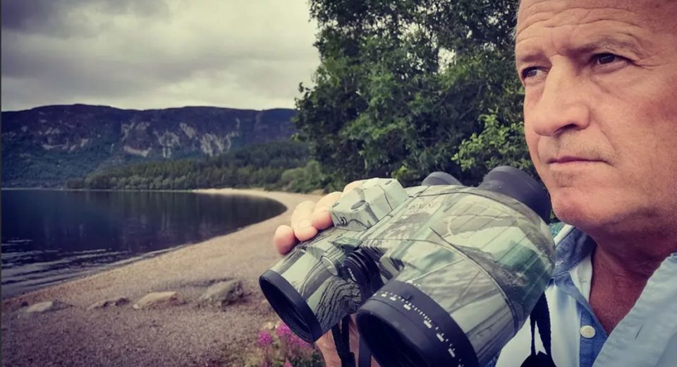Steve Feltham scans Loch Ness with binoculars during his search for the Loch Ness Monster