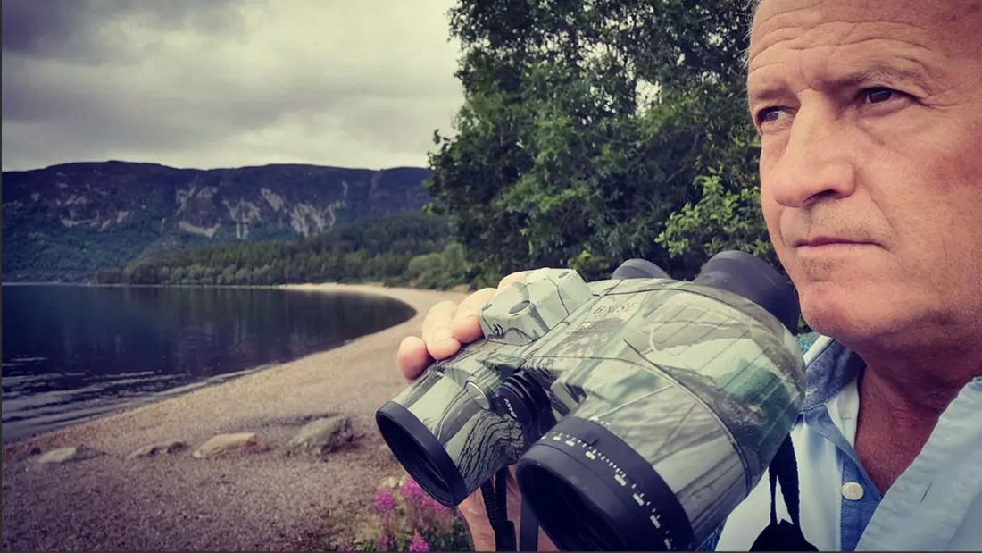 Steve Feltham scans Loch Ness with binoculars during his search for the Loch Ness Monster