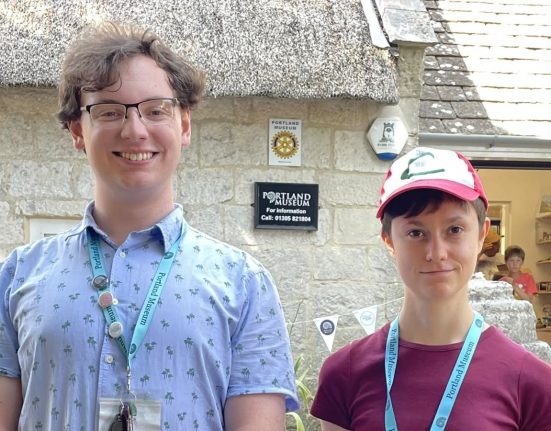 Jack Durie and Penelope Bentham, young volunteers at Portland Museum Dorset, standing outside the museum building