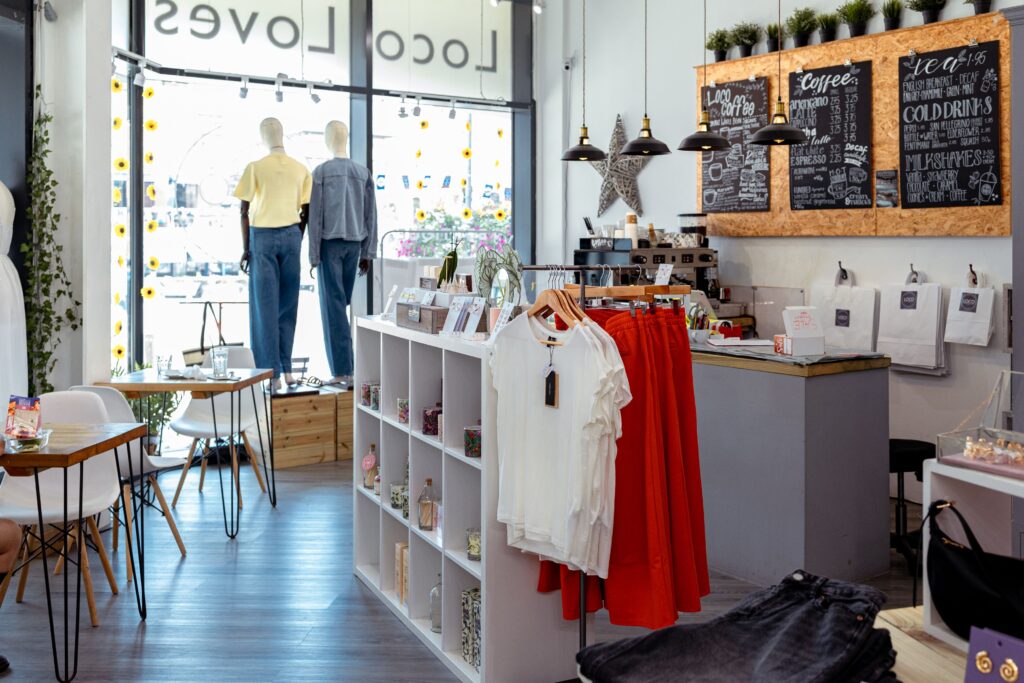 Inside Loco Loves at Brewery Square, a combined café and boutique with clothing rails, gift shelves and a coffee counter with chalkboard menu.
