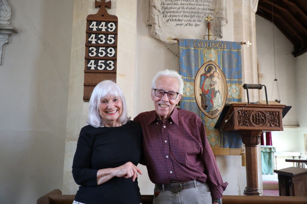 ally-Anne Barrett with church organist Keith Watts inside Thomas a Becket Church, Lydlinch, beneath the bell ringers' number board
