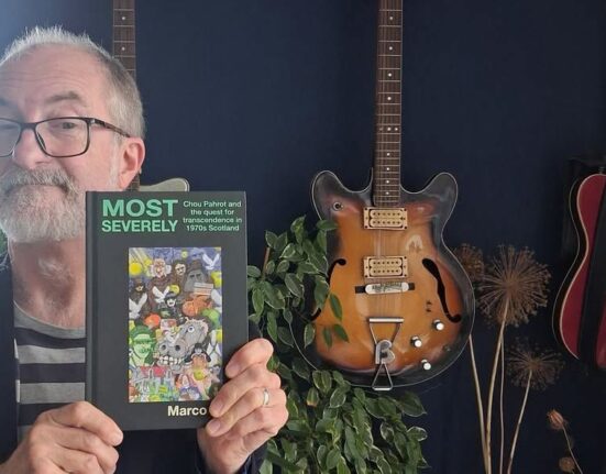 Dorset musician and author Marco Rossi holds his book Most Severely, about Scottish band Chou Pahrot