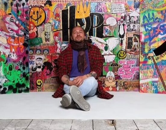 Artist Benji Weeratunge, aka Hot Noodle, sits in front of his colourful pop art paintings ahead of his Olive & Wilde Studios exhibition in Dorchester